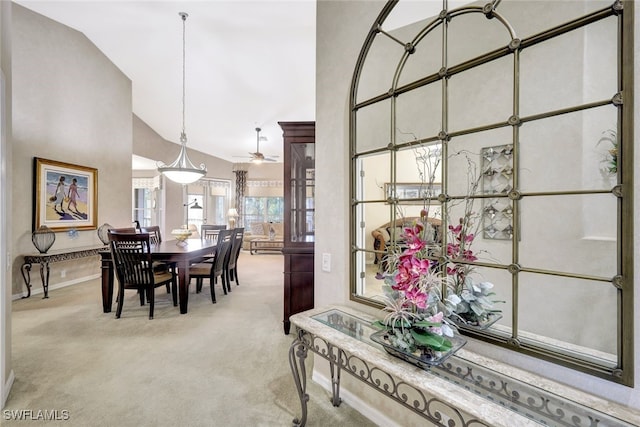 carpeted dining room with high vaulted ceiling