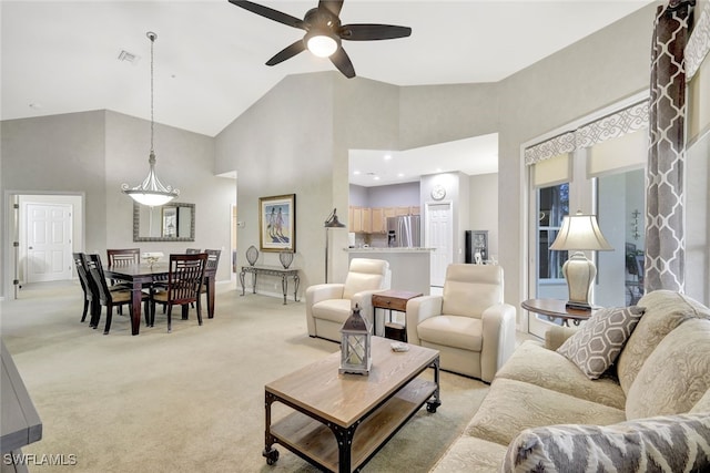 carpeted living room with high vaulted ceiling and ceiling fan