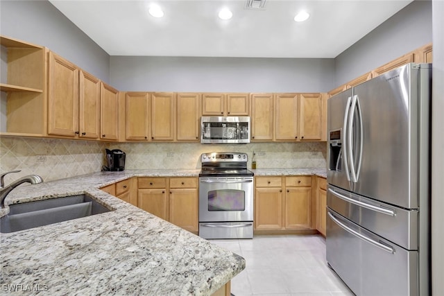 kitchen featuring sink, light tile patterned floors, appliances with stainless steel finishes, light stone countertops, and decorative backsplash