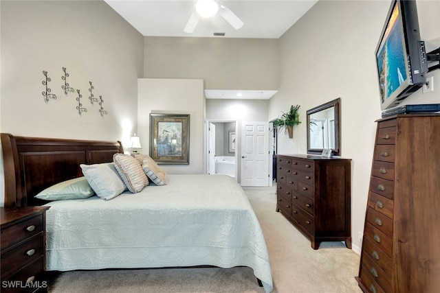 carpeted bedroom featuring ensuite bath and ceiling fan