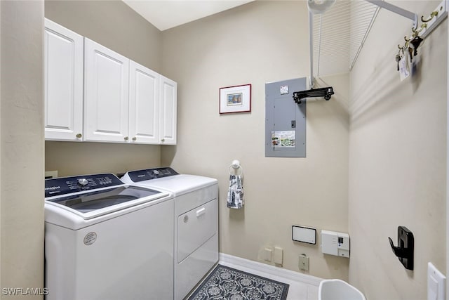 laundry area featuring separate washer and dryer, electric panel, and cabinets