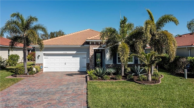 mediterranean / spanish-style home featuring a front yard and a garage