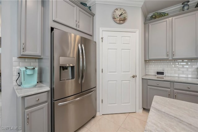 kitchen featuring gray cabinets, stainless steel fridge, and light tile patterned floors