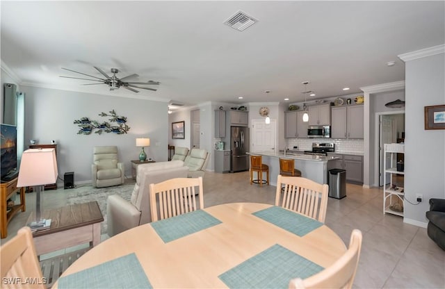 dining area featuring crown molding, sink, ceiling fan, and light tile patterned floors