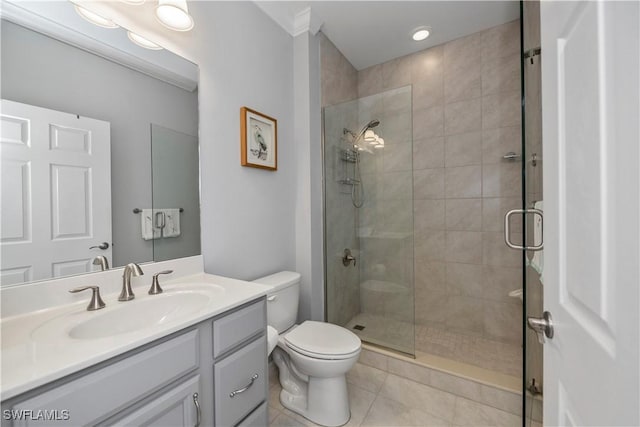 bathroom with toilet, vanity, tile patterned floors, and a shower with door