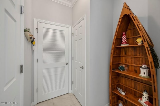 hall featuring crown molding and light tile patterned flooring