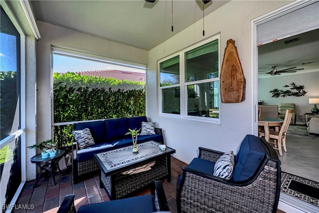 sunroom featuring ceiling fan