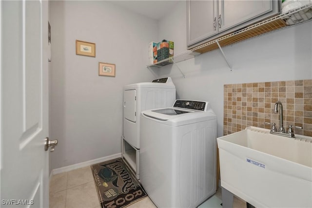 washroom featuring light tile patterned flooring, cabinets, sink, and washing machine and clothes dryer