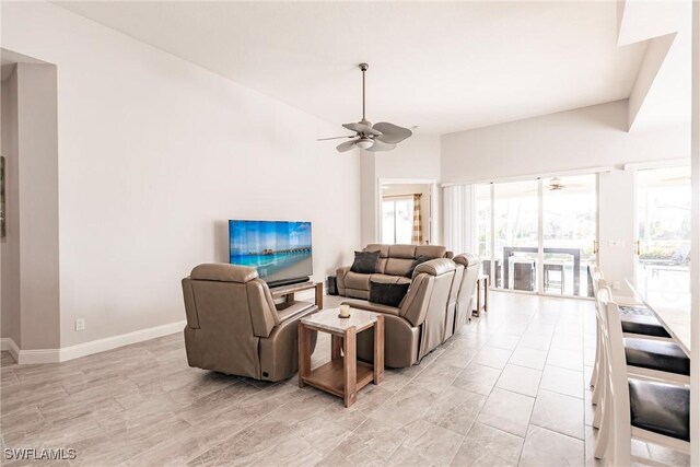 living room with ceiling fan and baseboards