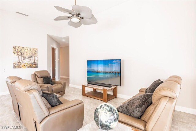 living room with ceiling fan, visible vents, and baseboards