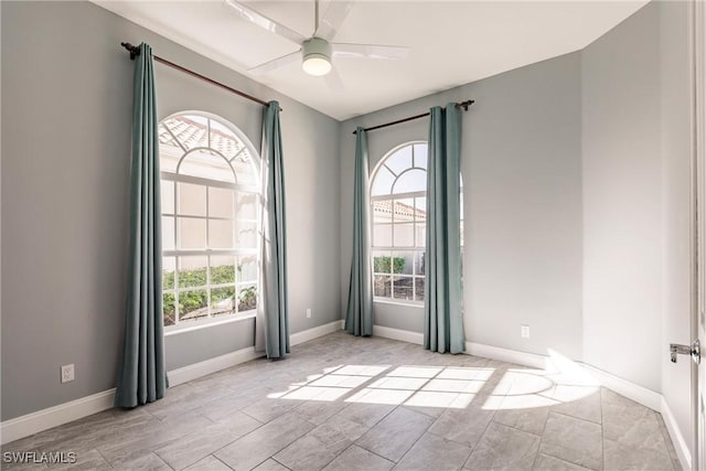 unfurnished room featuring ceiling fan and baseboards