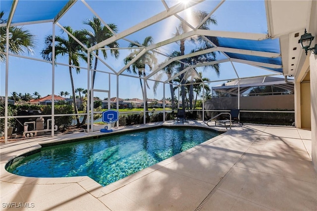 pool featuring glass enclosure and a patio area