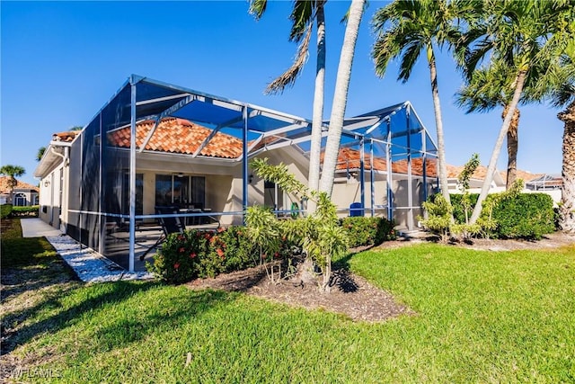 back of property featuring a lawn and a lanai