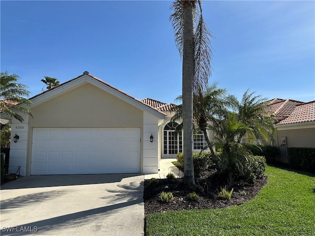 view of front of house featuring concrete driveway, an attached garage, and stucco siding