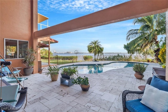 view of pool featuring a patio area and a water view