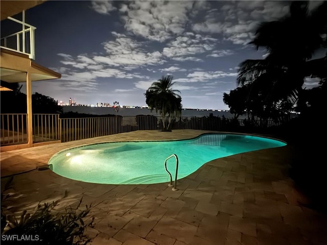 pool at dusk featuring a patio