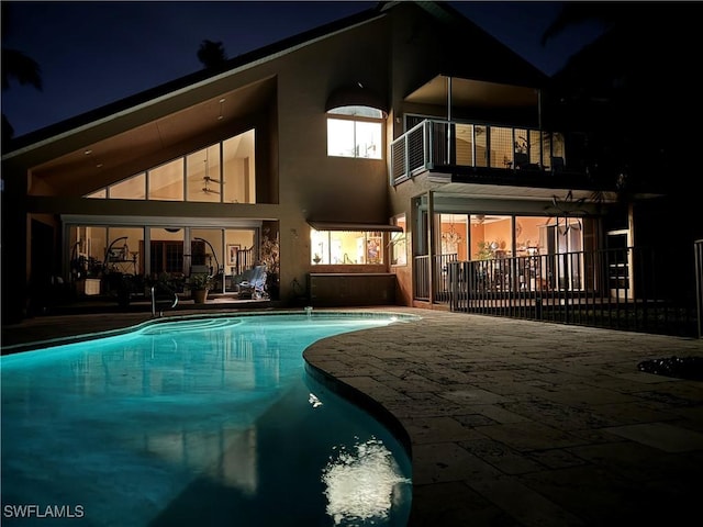 back house at twilight with a patio area