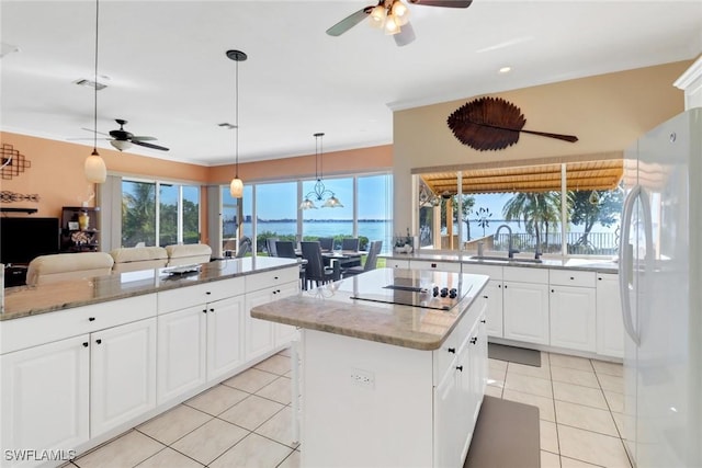 kitchen with sink, white cabinetry, a center island, white fridge, and light tile patterned floors