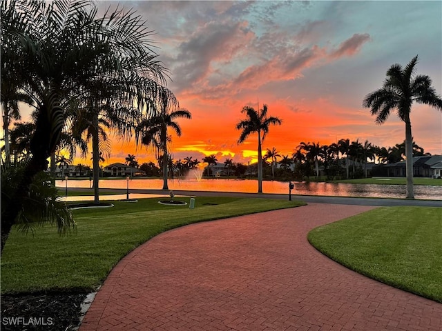 surrounding community with a lawn and a water view