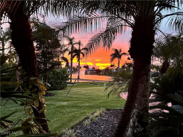 view of home's community featuring a lawn and a water view