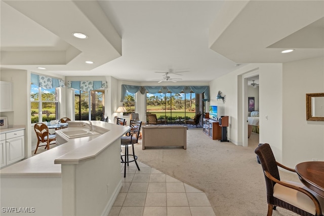 kitchen featuring plenty of natural light, light colored carpet, sink, and a breakfast bar area