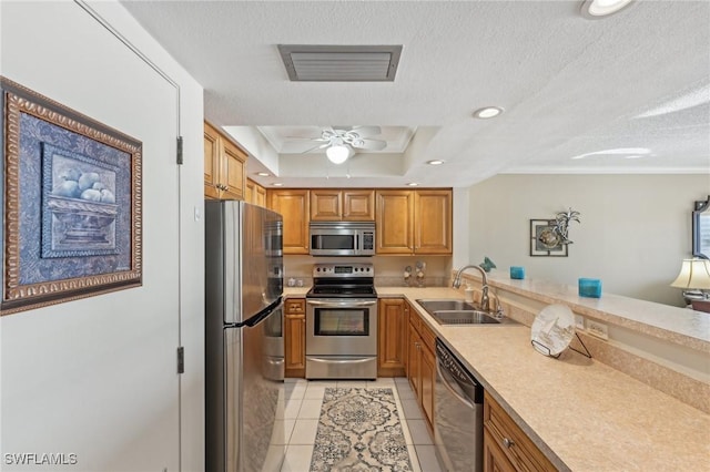 kitchen with sink, light tile patterned floors, a textured ceiling, and appliances with stainless steel finishes