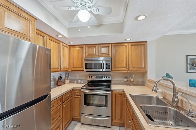 kitchen featuring a raised ceiling, sink, light tile patterned floors, ornamental molding, and appliances with stainless steel finishes