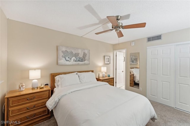 bedroom with carpet flooring, ceiling fan, a textured ceiling, and a closet