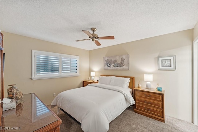 bedroom with a textured ceiling, carpet floors, and ceiling fan