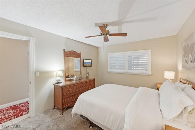 bedroom featuring carpet flooring, ceiling fan, and a textured ceiling