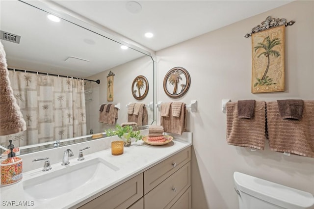 bathroom with vanity, a shower with shower curtain, and toilet