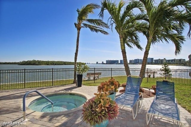 view of pool featuring a community hot tub and a water view