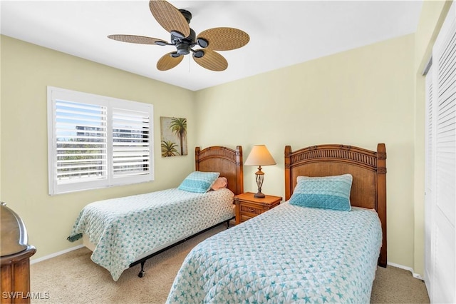 carpeted bedroom with ceiling fan and a closet