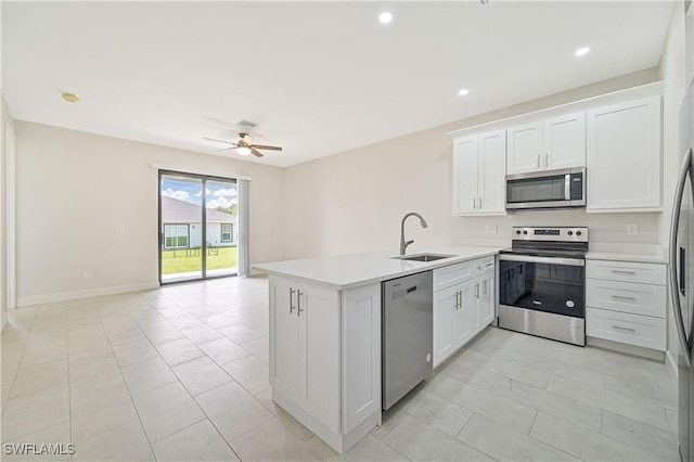 kitchen featuring kitchen peninsula, stainless steel appliances, ceiling fan, sink, and white cabinets