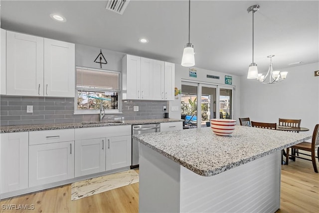 kitchen featuring dishwasher, white cabinetry, a healthy amount of sunlight, and sink