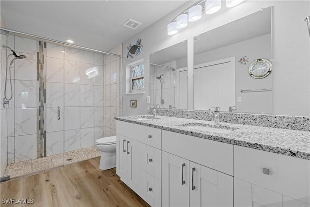 bathroom with vanity, wood-type flooring, an enclosed shower, and toilet