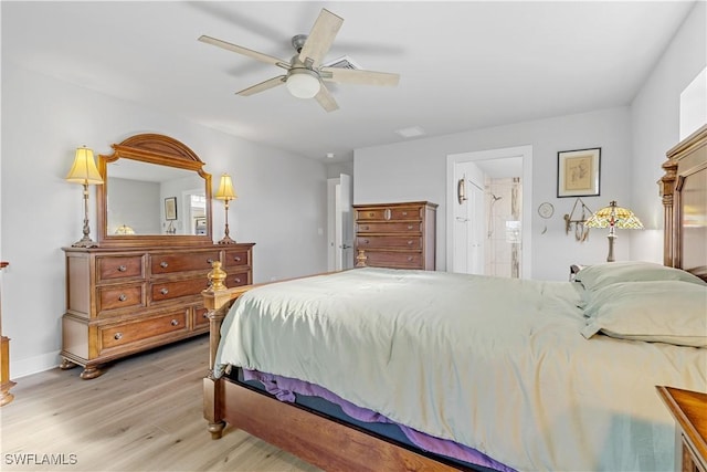 bedroom featuring ceiling fan, light hardwood / wood-style floors, and ensuite bath