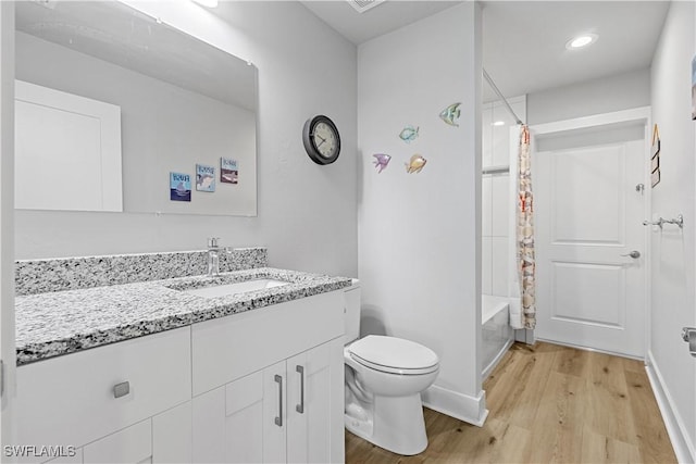 full bathroom with hardwood / wood-style floors, vanity, toilet, and shower / bath combo with shower curtain