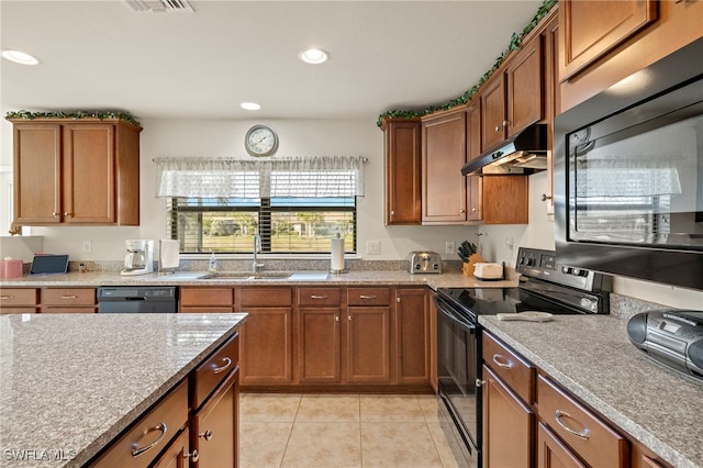 kitchen featuring black appliances, light stone counters, light tile patterned floors, and sink