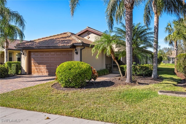 mediterranean / spanish home with a front lawn and a garage