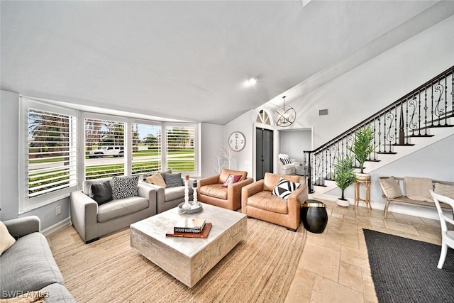 living room featuring vaulted ceiling and a notable chandelier