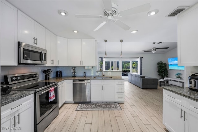 kitchen with sink, white cabinets, light hardwood / wood-style flooring, and appliances with stainless steel finishes