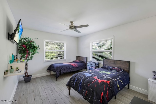 bedroom featuring light hardwood / wood-style flooring, multiple windows, and ceiling fan