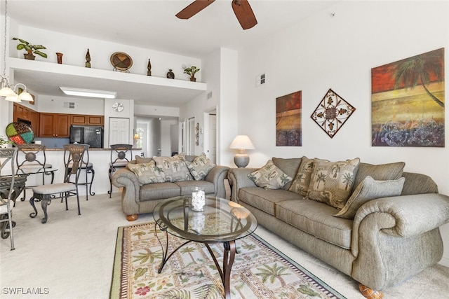 carpeted living room with ceiling fan