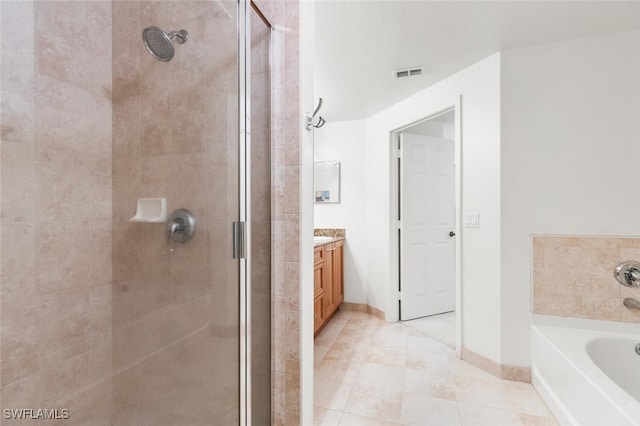 bathroom featuring tile patterned flooring, vanity, and plus walk in shower