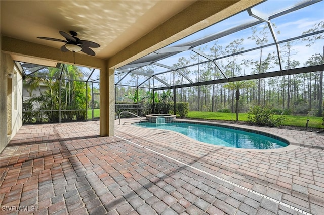 view of pool with a pool with connected hot tub, glass enclosure, a patio, and ceiling fan