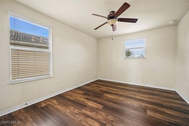 spare room with wood finished floors, a ceiling fan, and baseboards