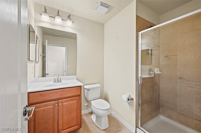 bathroom featuring tile patterned flooring, toilet, vanity, and walk in shower