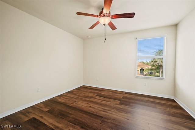 unfurnished room featuring dark wood-style flooring, ceiling fan, and baseboards