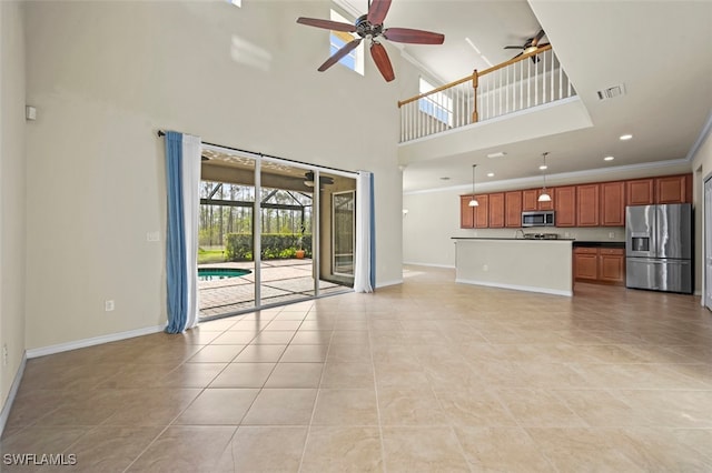 unfurnished living room with ornamental molding, a sunroom, visible vents, and baseboards